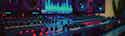 What is Mastering? Understanding Music Mastering - iMusician header Sound mixing console with numerous faders, knobs, and LED displays in a dark, colorful lighting environment.